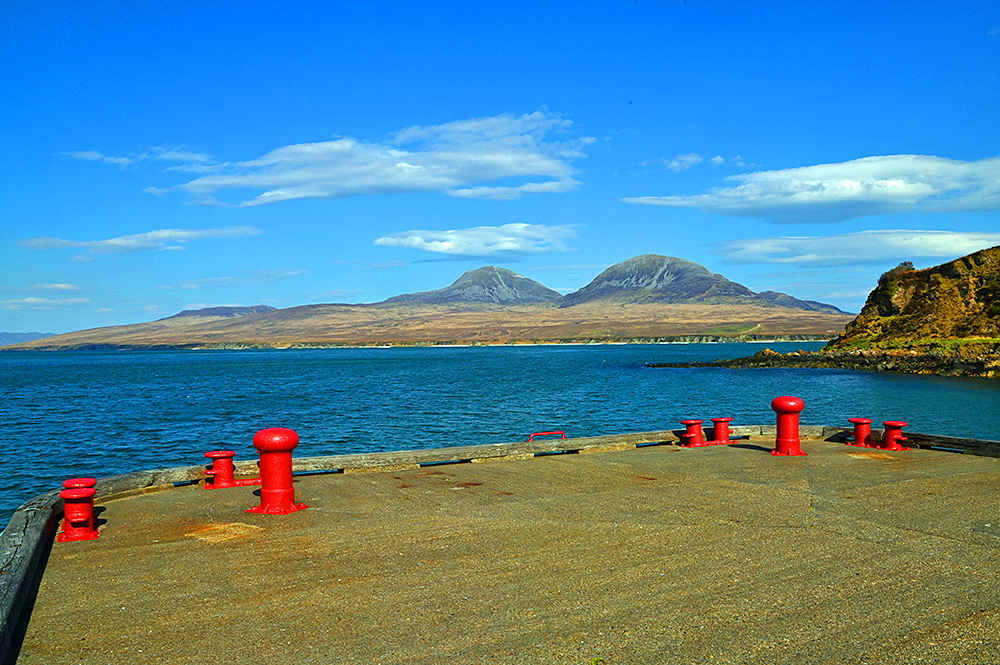 Picture of two mountains seen across a sound between two islands from a pier with some bright red clamps