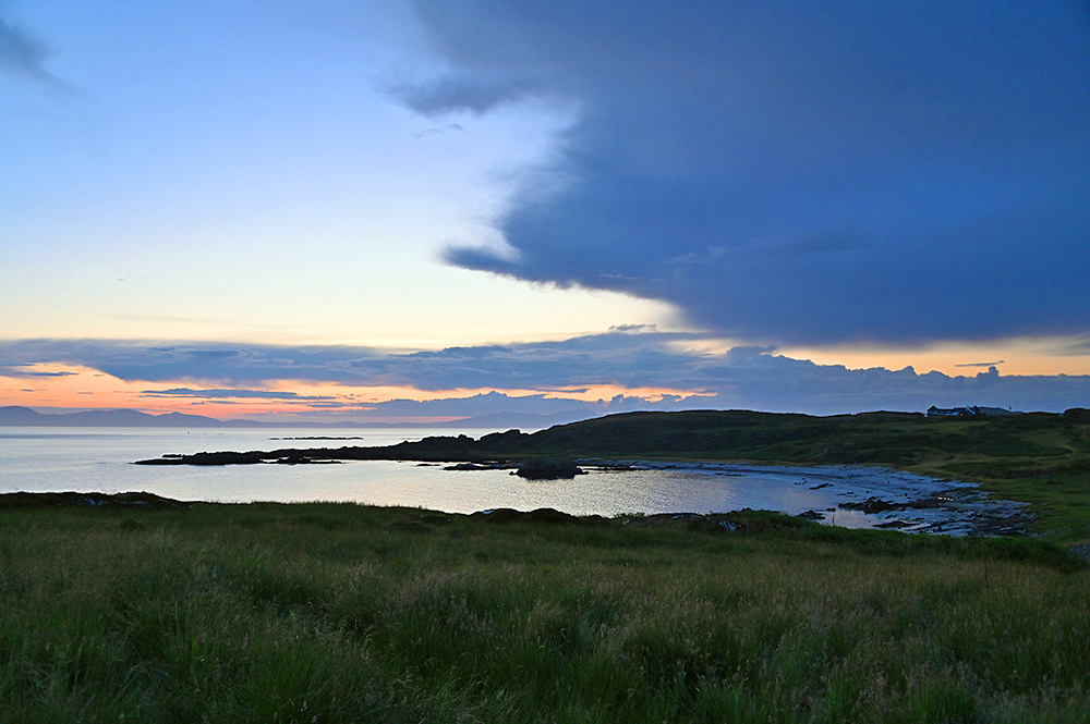 Picture of a bay with a sandy island beach in the last light of the gloaming, two other islands in the distance