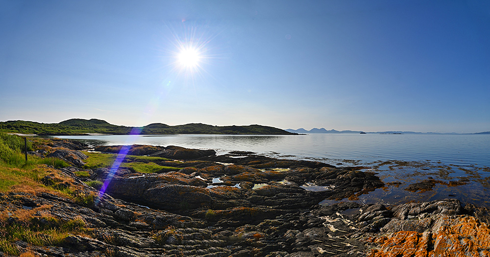 Panoramic picture of a view over two islands under a bright sun