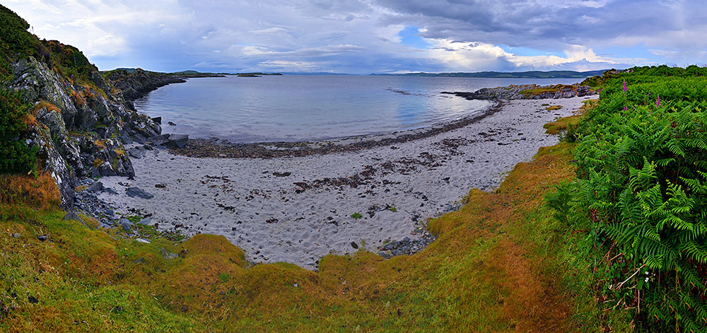 Panoramic picture of a small beach at a sound between an island and the mainland