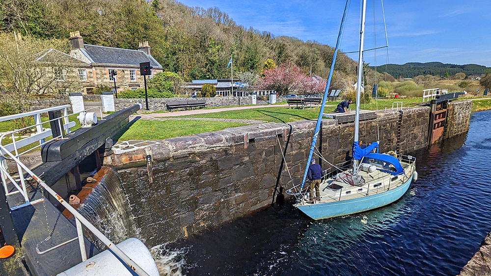 Picture of a light blue sailing yacht entering an old canal lock