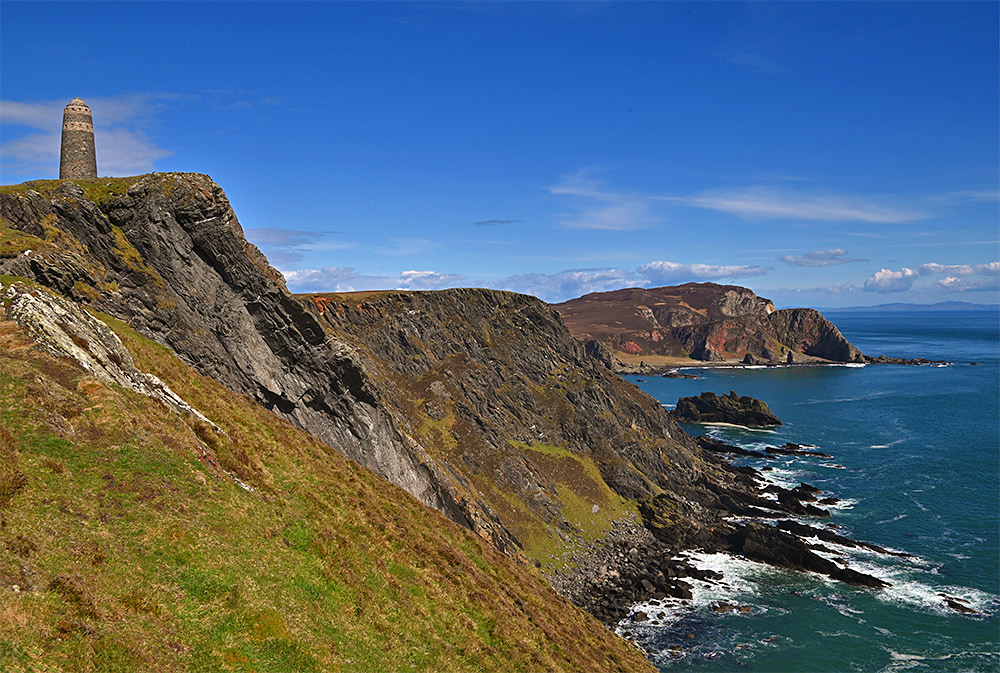 Picture of a stone tower (the American Monument) on top of some steep dramatic coastal cliffs