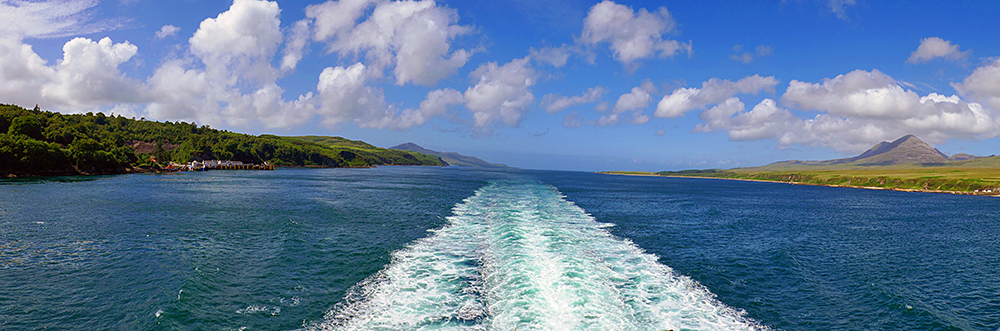 Panoramic picture of a view back from a ferry over a sound between two islands