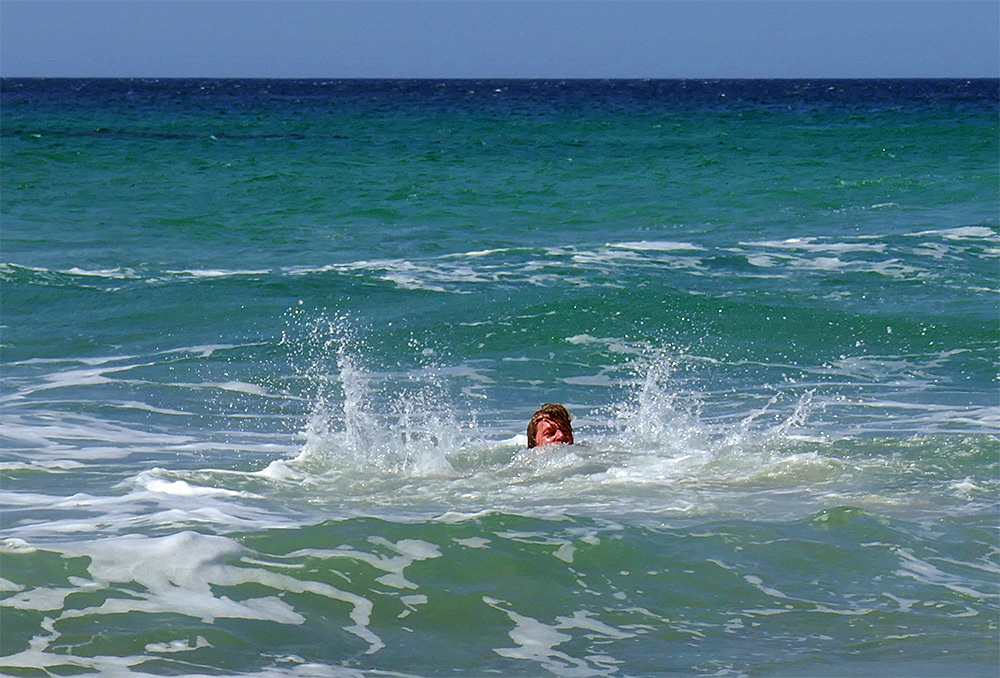 Picture of a person splashing in the water off a beach