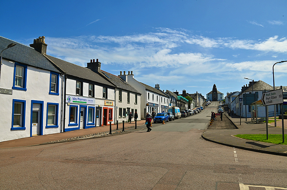 Picture of a view up a village street, stores along the street and a round church at the top of the street