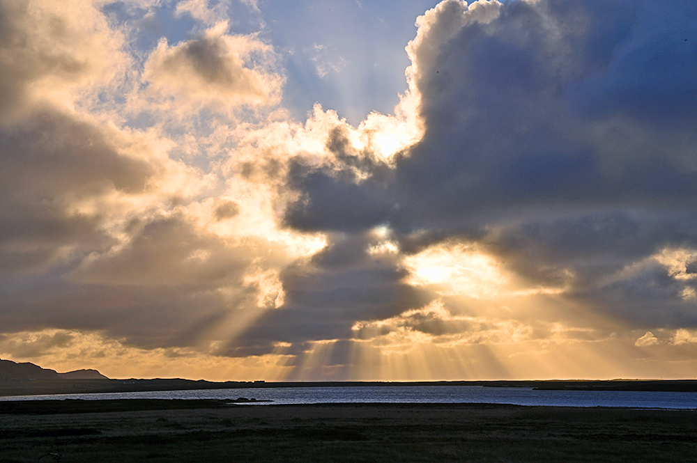 Picture of a colourful sunburst over a freshwater loch