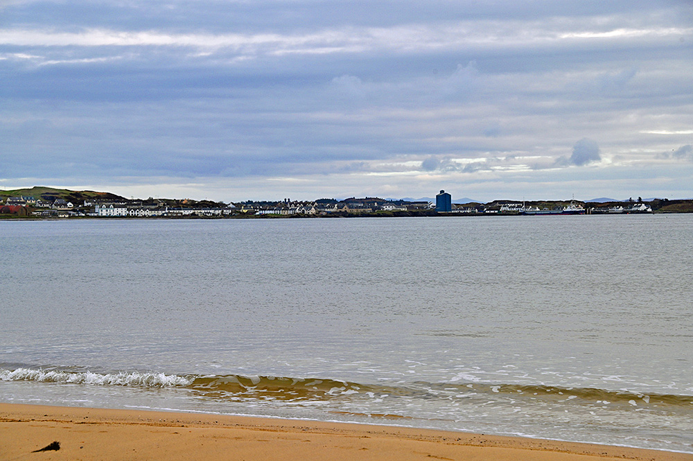 Picture of a coastal village with a ferry port, seen from a beach