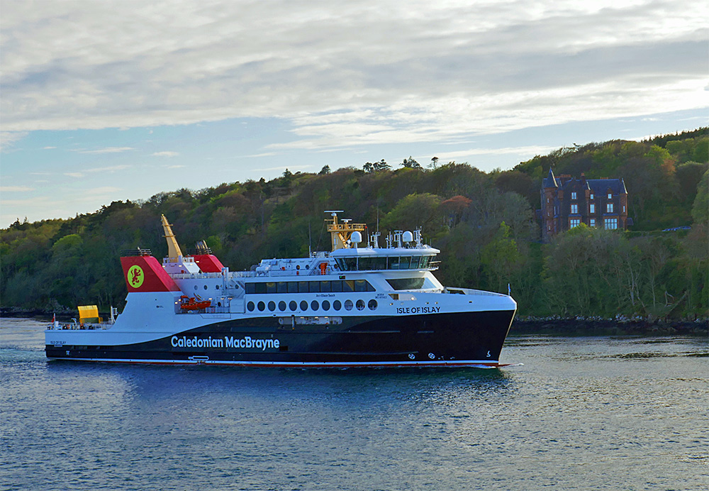 Picture of the Calmac ferry MV Isle of Islay passing a baronial mansion in some mild April evening light