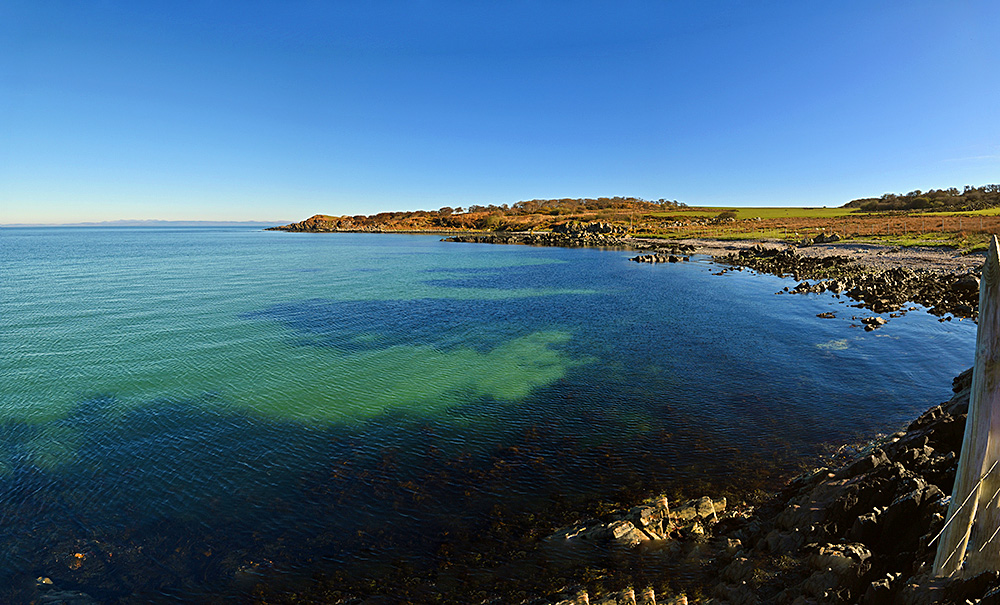 Panoramic picture of a small bay with a nice shoreline, some rocks, some beach