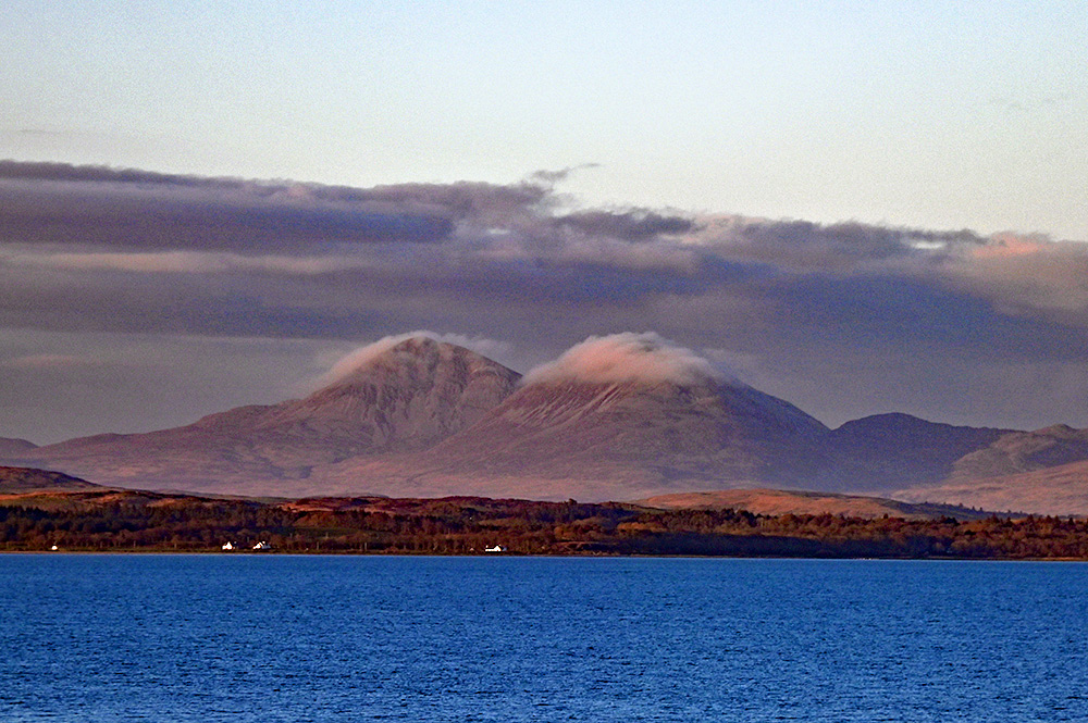 Picture of two mountain with a cloud cap, seen across a sea loch