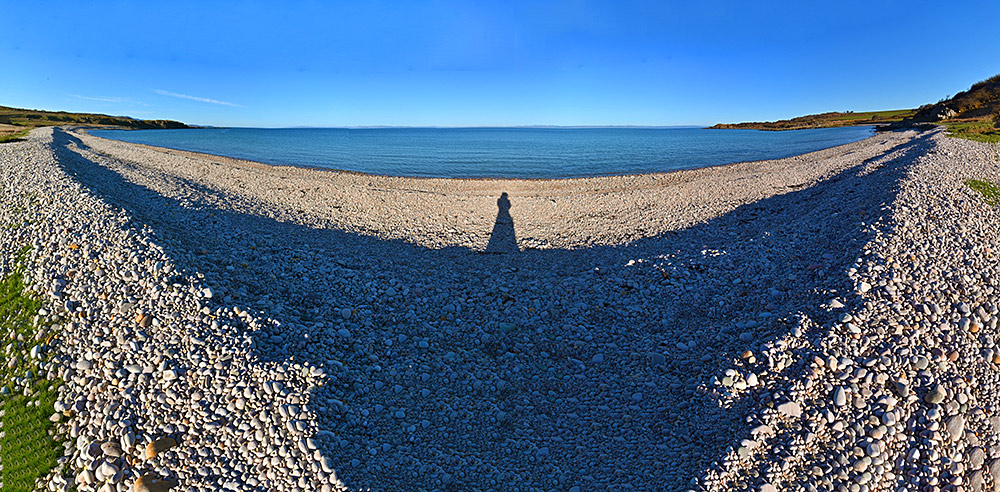 Panoramic picture of a pebble beach in a wide bay