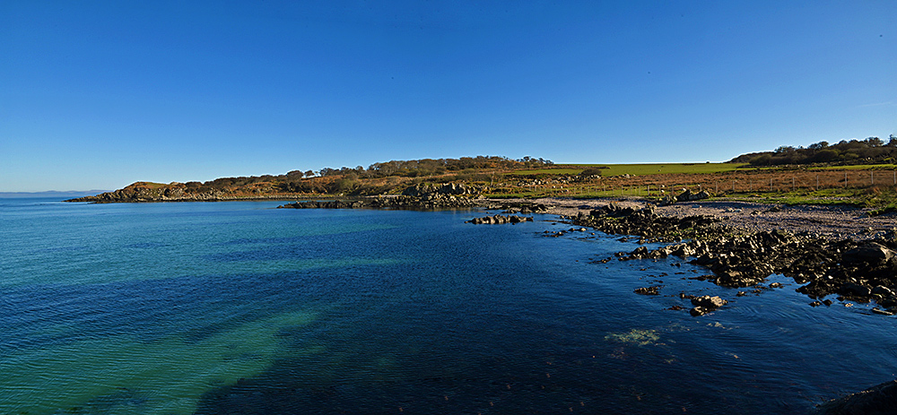 Panoramic picture of a small bay with a varied shoreline in beautiful April sunshine