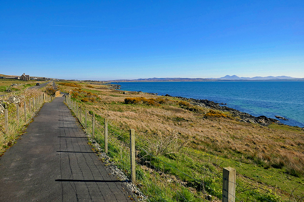 Picture of a tarmac footpath along a sea loch on a bright sunny day