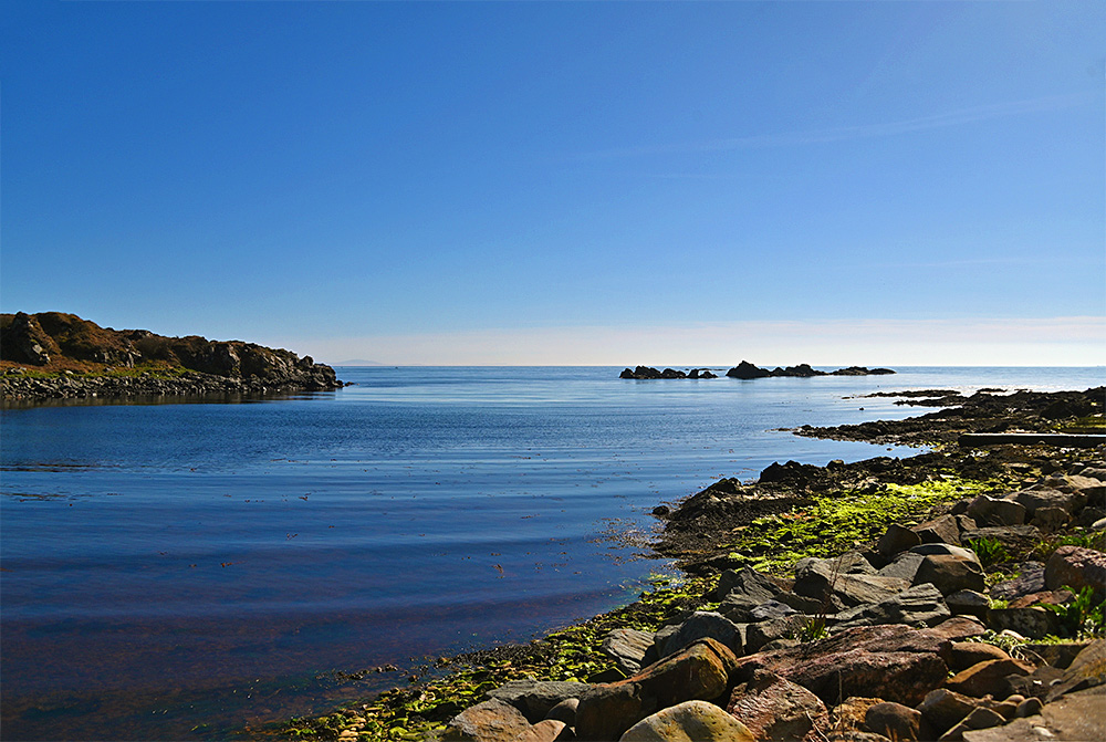 Picture of a small lea loch with a rocky shore in beautiful April sunshine