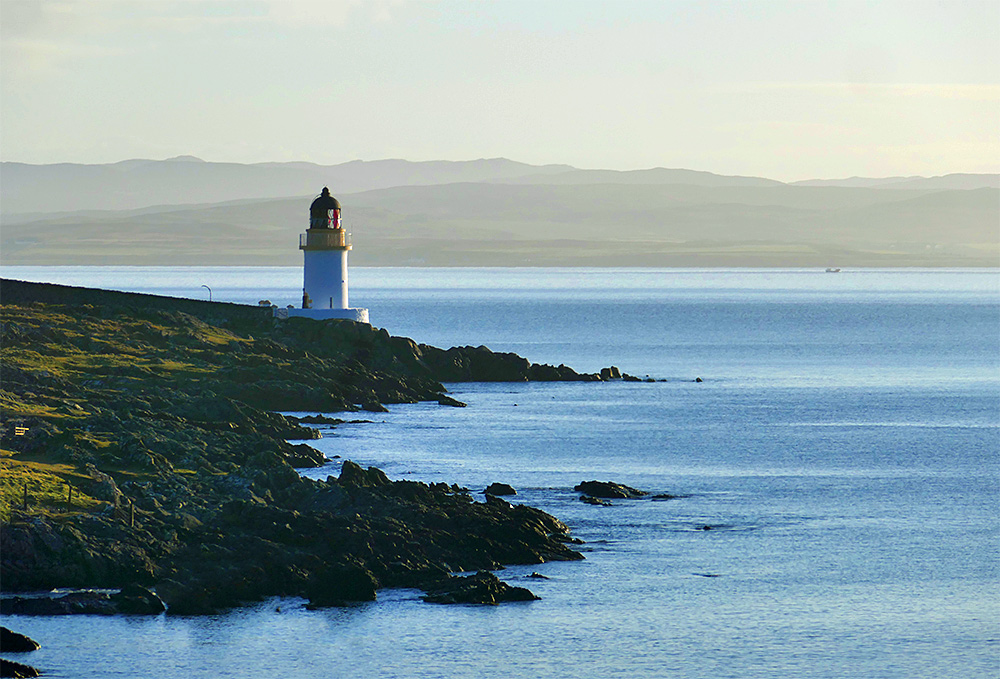 Picture of a small lighthouse on a rocky sea loch shore in some beautiful April morning sunshine