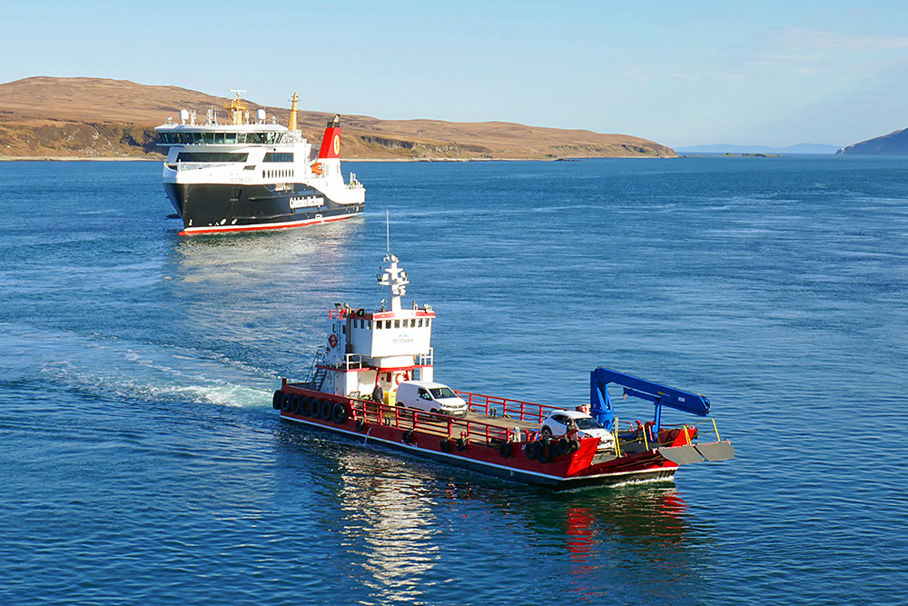 Picture of a small local ferry (MV James) and a large ferry (MV Isle of Islay) in a sound between two islands