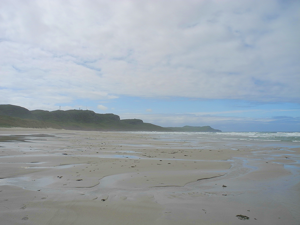 Picture of a wide sandy beach on a mostly damp and drizzly day