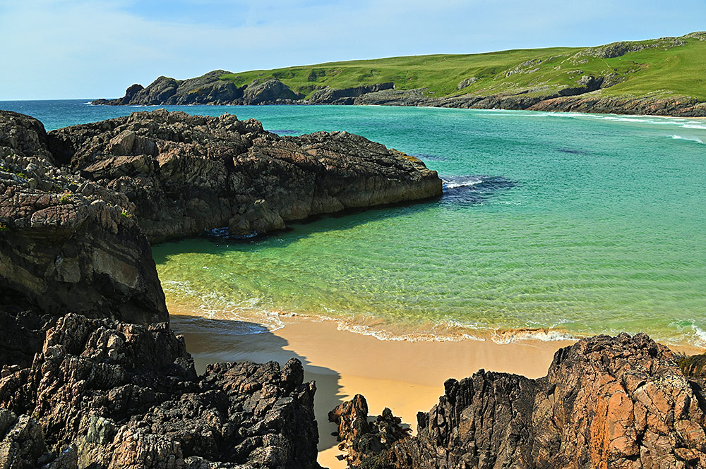 Picture of a bay with rocky cliffs and a sandy beach