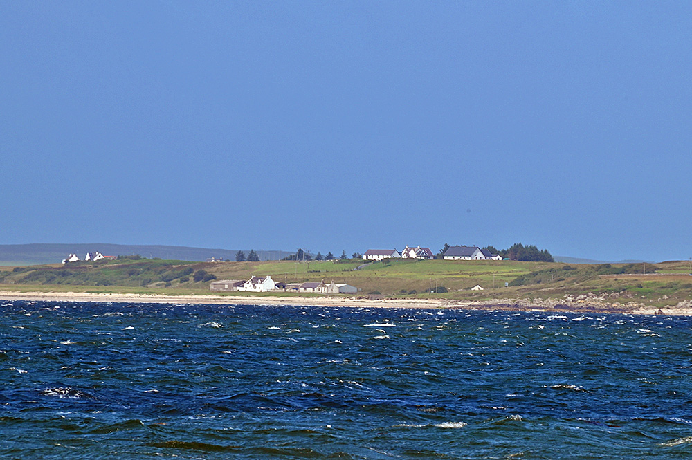 Picture of three small coastal settlements seen across a sea loch