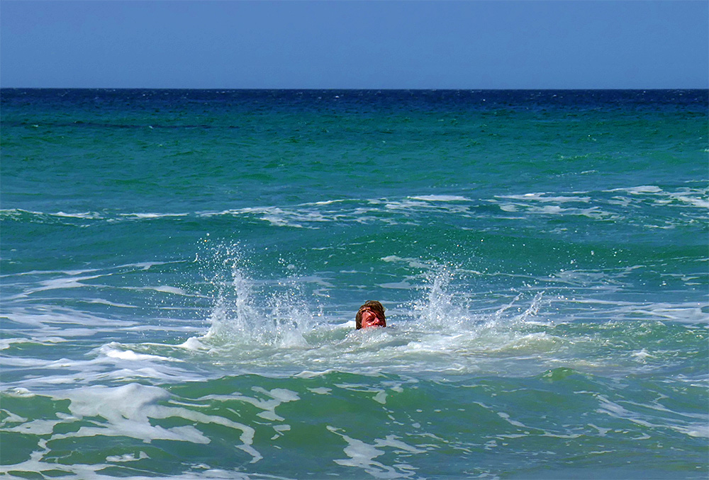 Picture of a person splashing in the shallow water close to a beach